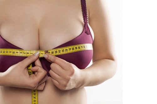 woman is measuring her bra size at home